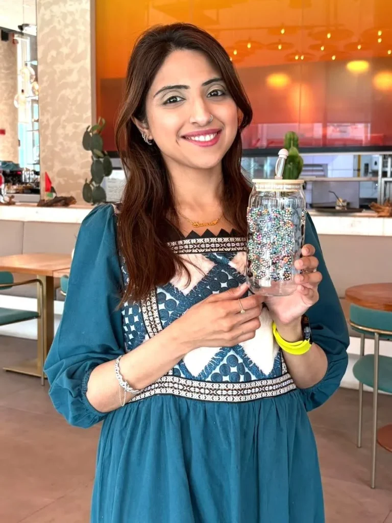 Suman Shafi decorating a glass tumbler with colourful embellishments